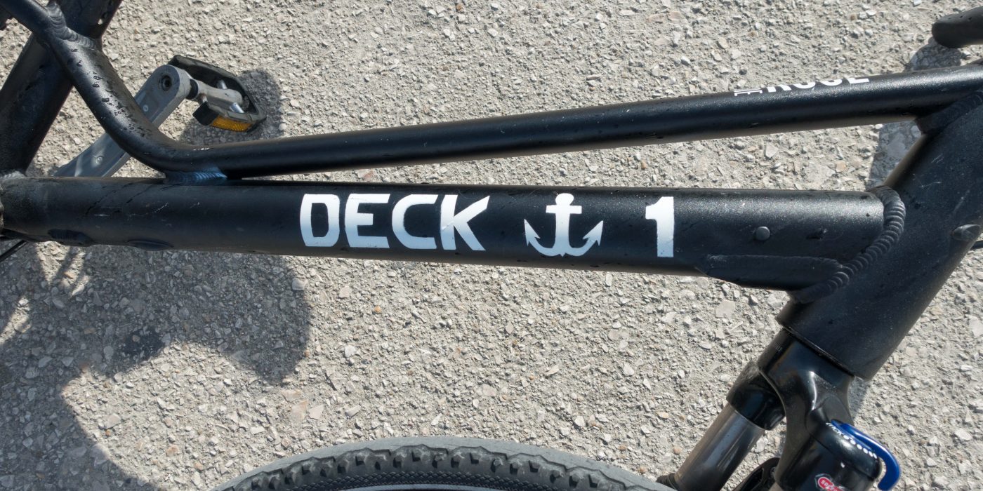 Schwarzer Fahrradrahmen mit weißem Anker und der Aufschrift "Deck 1"